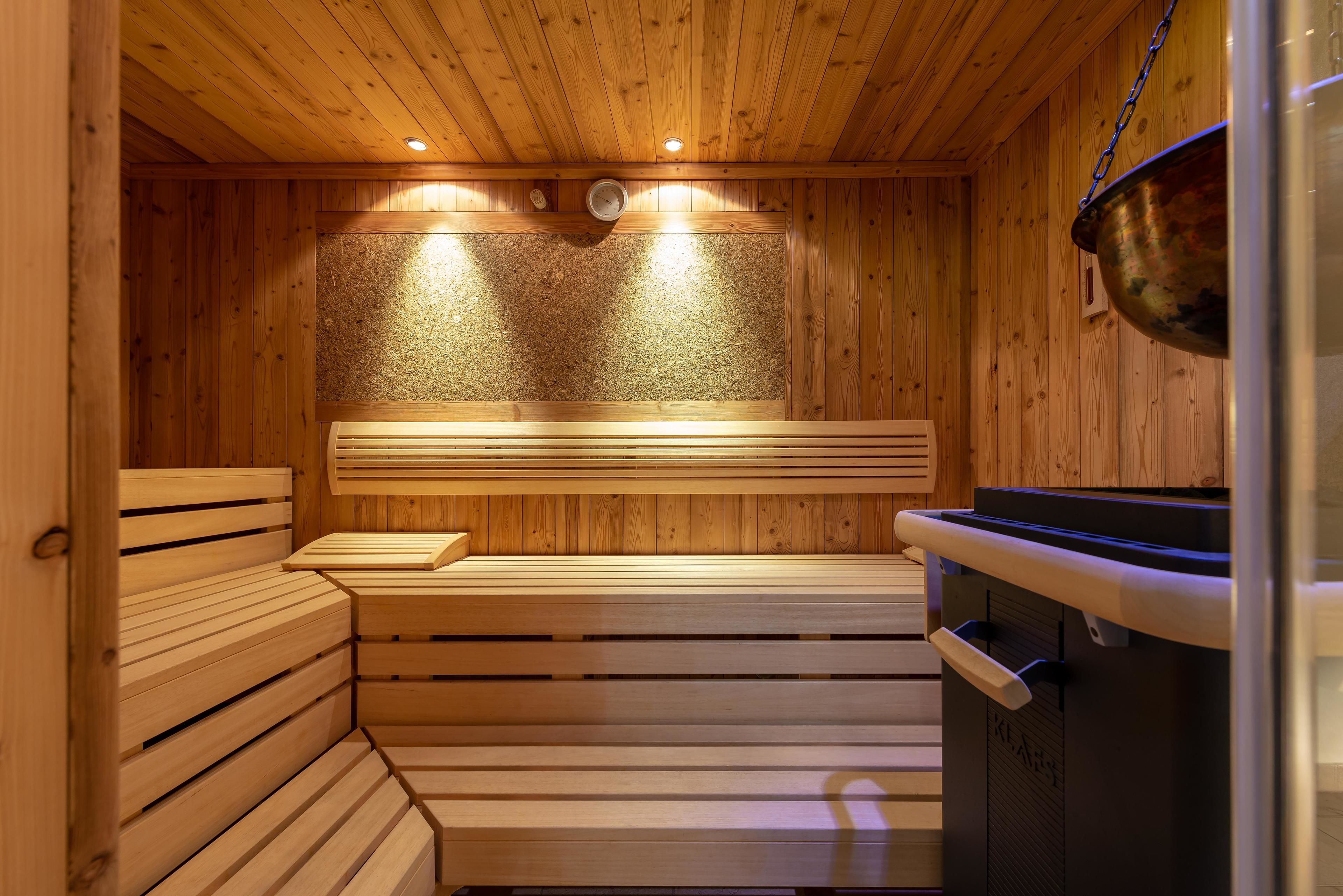 A wooden sauna with benches and a steam shower.