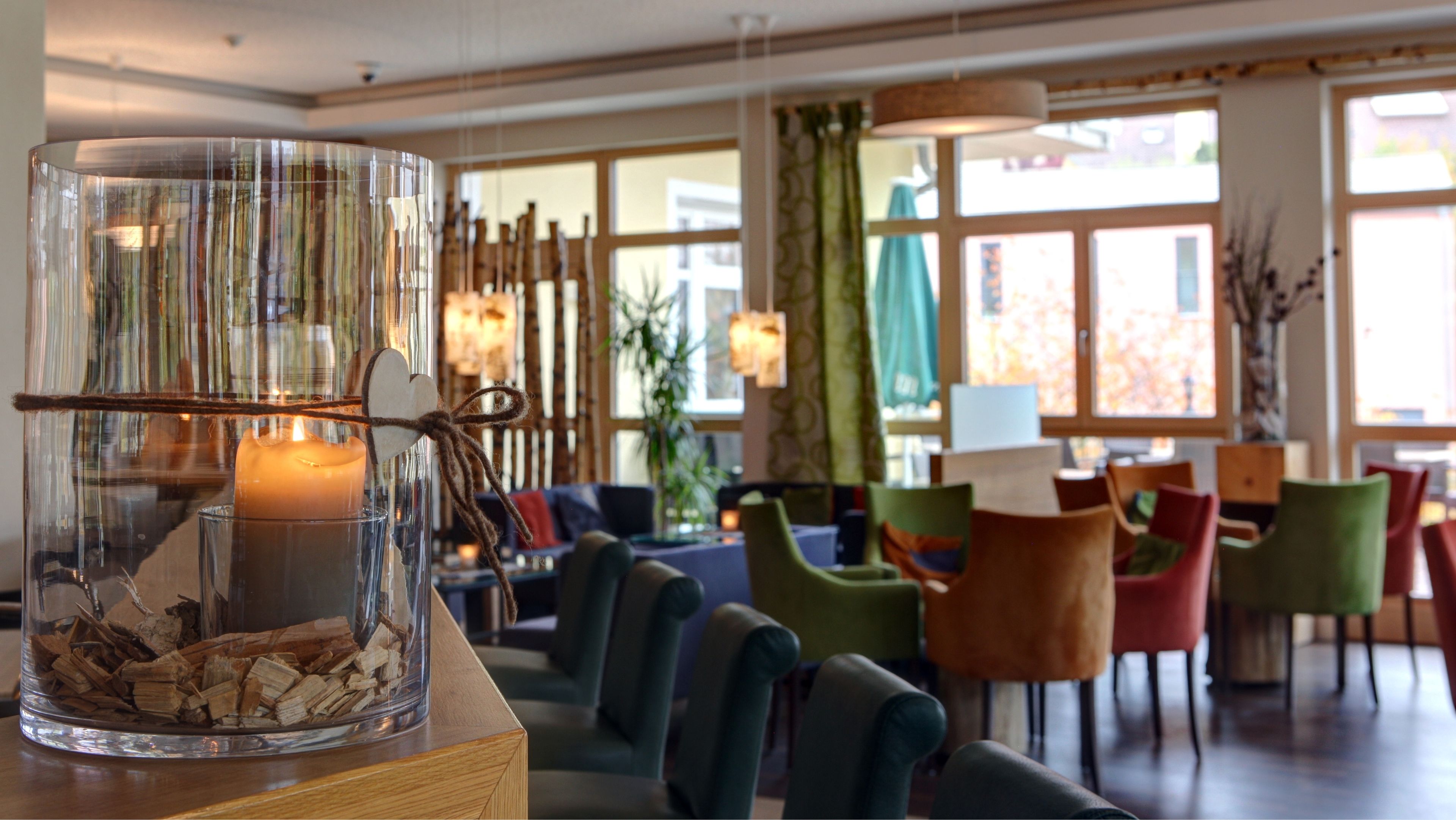 A cozy seating area with a glass table centerpiece containing a candle and wood shavings.