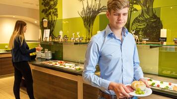 A buffet area with a variety of food items and a decorative wall with floral designs.