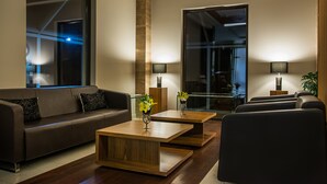 A modern living room with a sofa, two coffee tables, and lamps. - Rado Resort Spa & Wellness (Mielec)