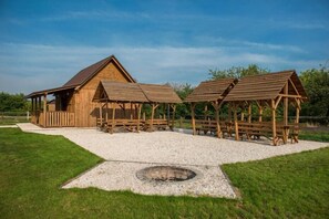 A rustic wooden cabin with a sloped roof and a separate wooden structure with a roof.