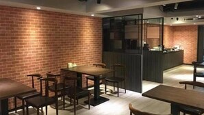 Un comedor moderno con paredes de ladrillo y mesas y sillas de madera.