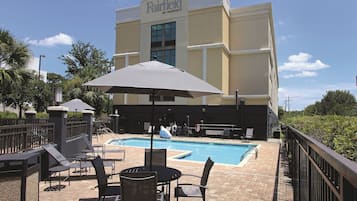 Alberca al aire libre, sombrillas en la alberca y camastros