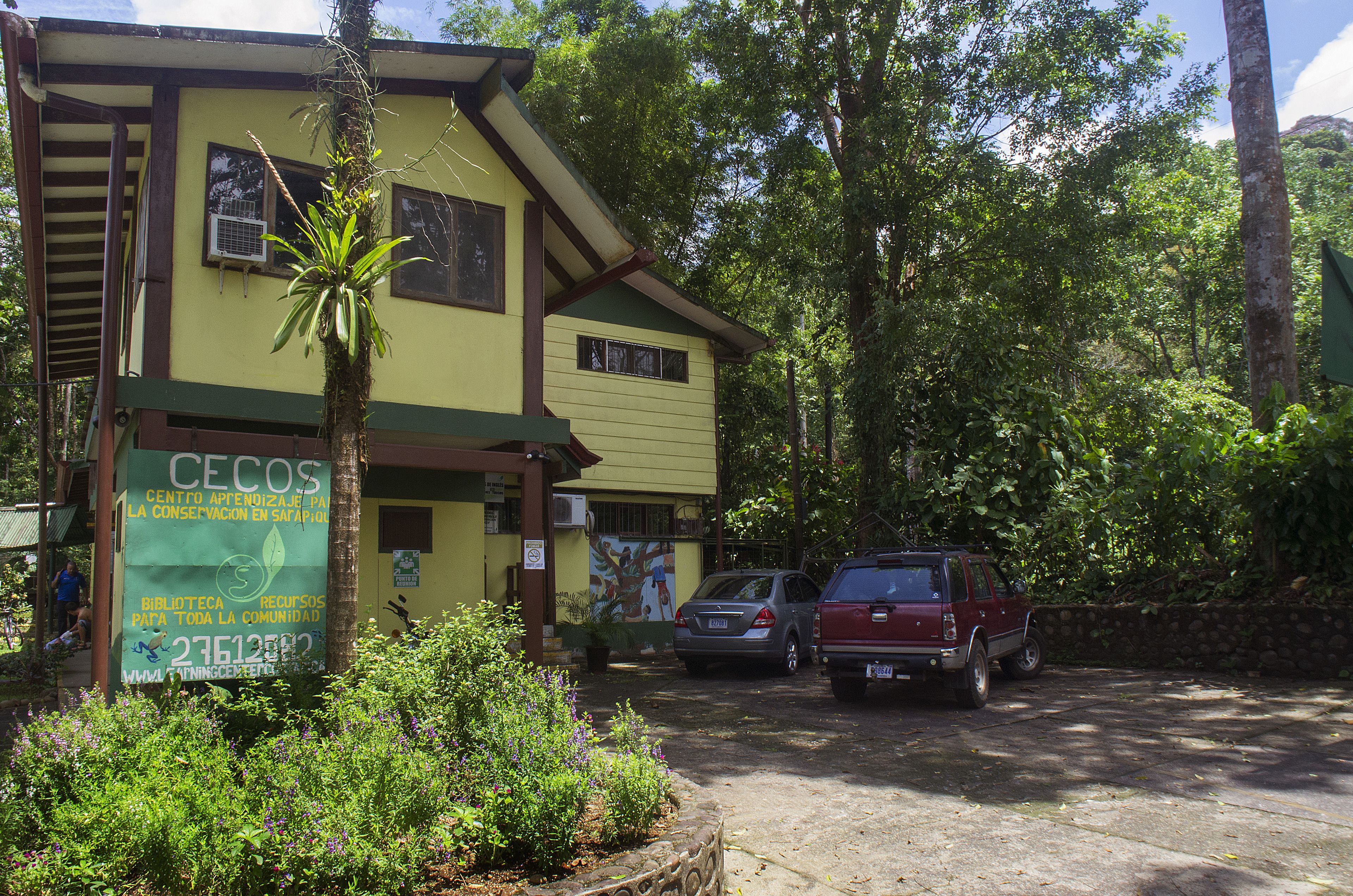 A building with a signboard advertising a community library and conservation efforts.