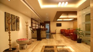 A lobby with a reception desk, seating area, and decorative elements.