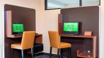 Dos estaciones de trabajo con computadoras, cada una con una silla, en una oficina moderna.