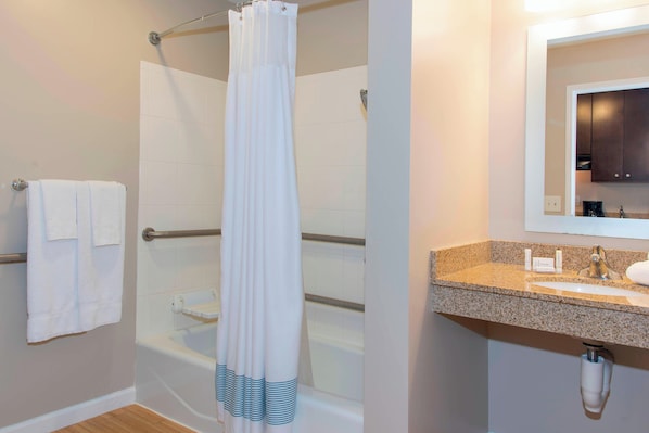 A bathroom with a shower, a bathtub, a sink, and a mirror.