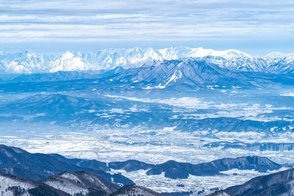 A panoramic view of snow-covered mountains with a valley below.
