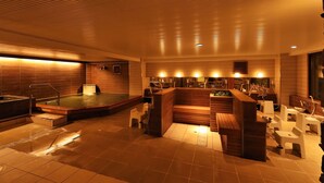 A spa area with a hot tub, seating, and a reception desk. - Shiga Park Hotel (Yamanouchi)