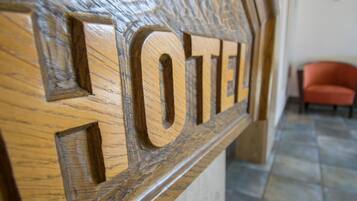 Un letrero de madera con la palabra 'HOTEL' tallada.