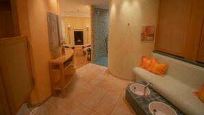A bathroom with a bathtub, two sinks, a vanity, and a mirror. - ART-Hotel Braun (Kirchheimbolanden)