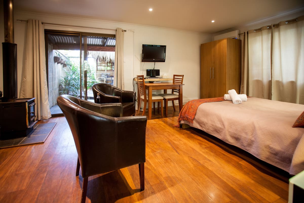 Une chambre d’hôtel comprenant un lit, un bureau avec une chaise, une télévision et une vue sur l’extérieur.