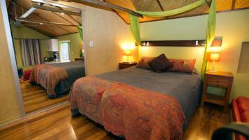 Een slaapkamer met een groot bed, twee nachtkastjes met lampen, een spiegel en een rode stoel.