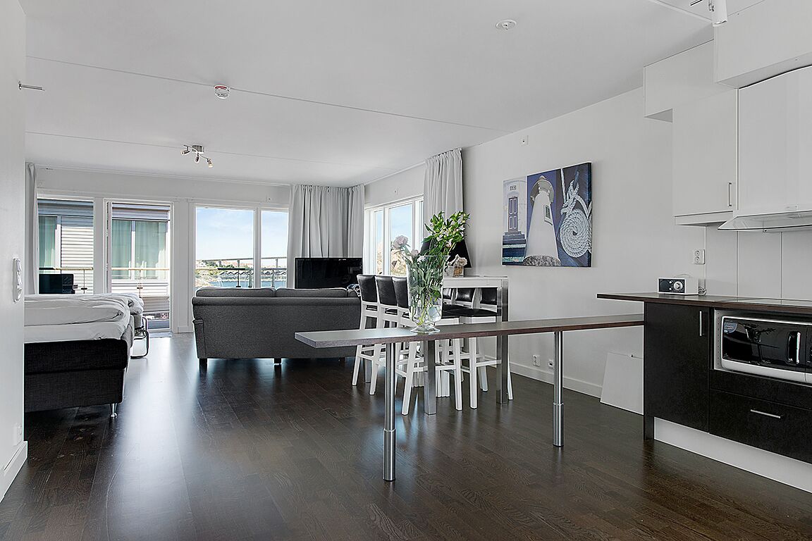 A modern apartment with a dining area, kitchen, and living room.