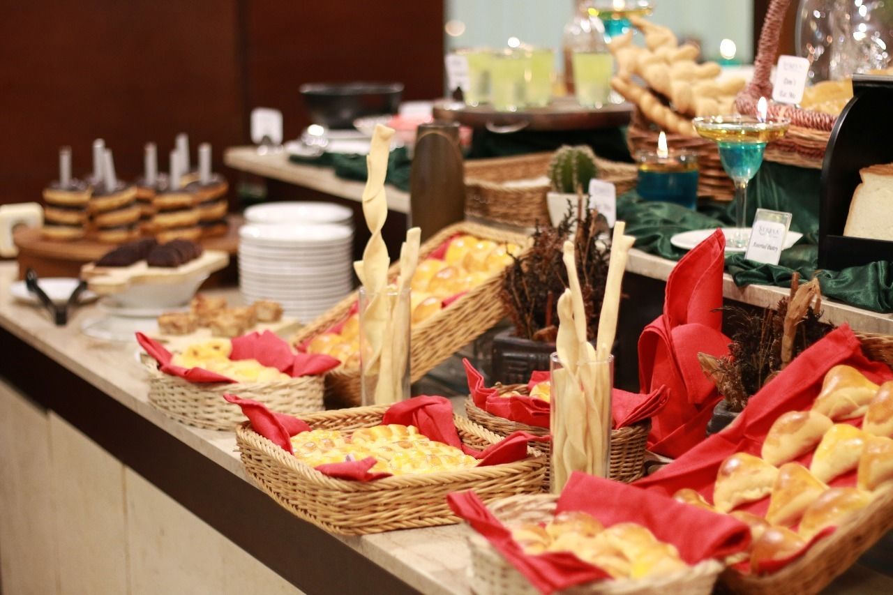 A buffet with various food items displayed in baskets and on plates, including pastries and desserts.