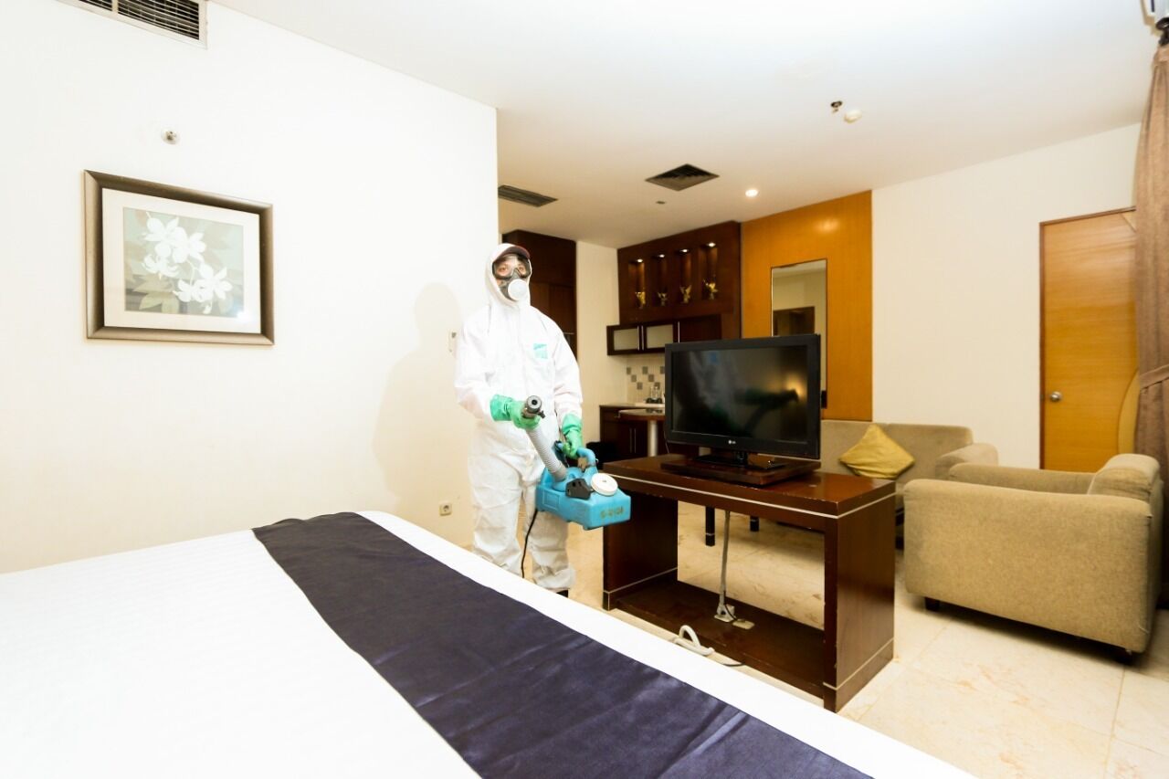 Una habitación de hotel con cama, televisión, escritorio y silla.