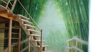 A staircase leading up to a room with a bamboo forest mural on the walls. - Artharmony Pension & Hostel (Prague)