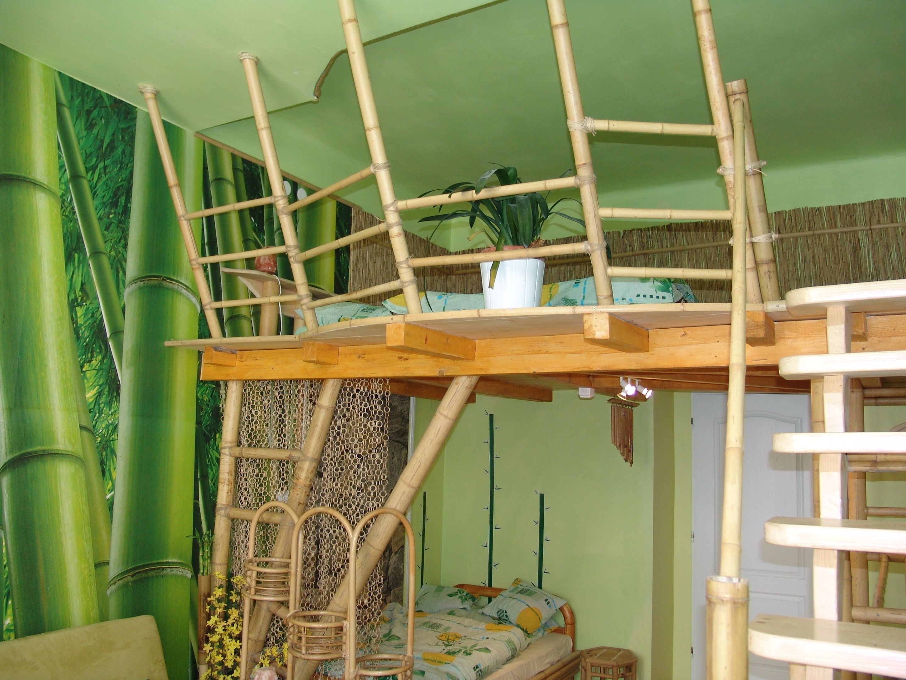 A bunk bed with a wooden ladder and a small table on top.