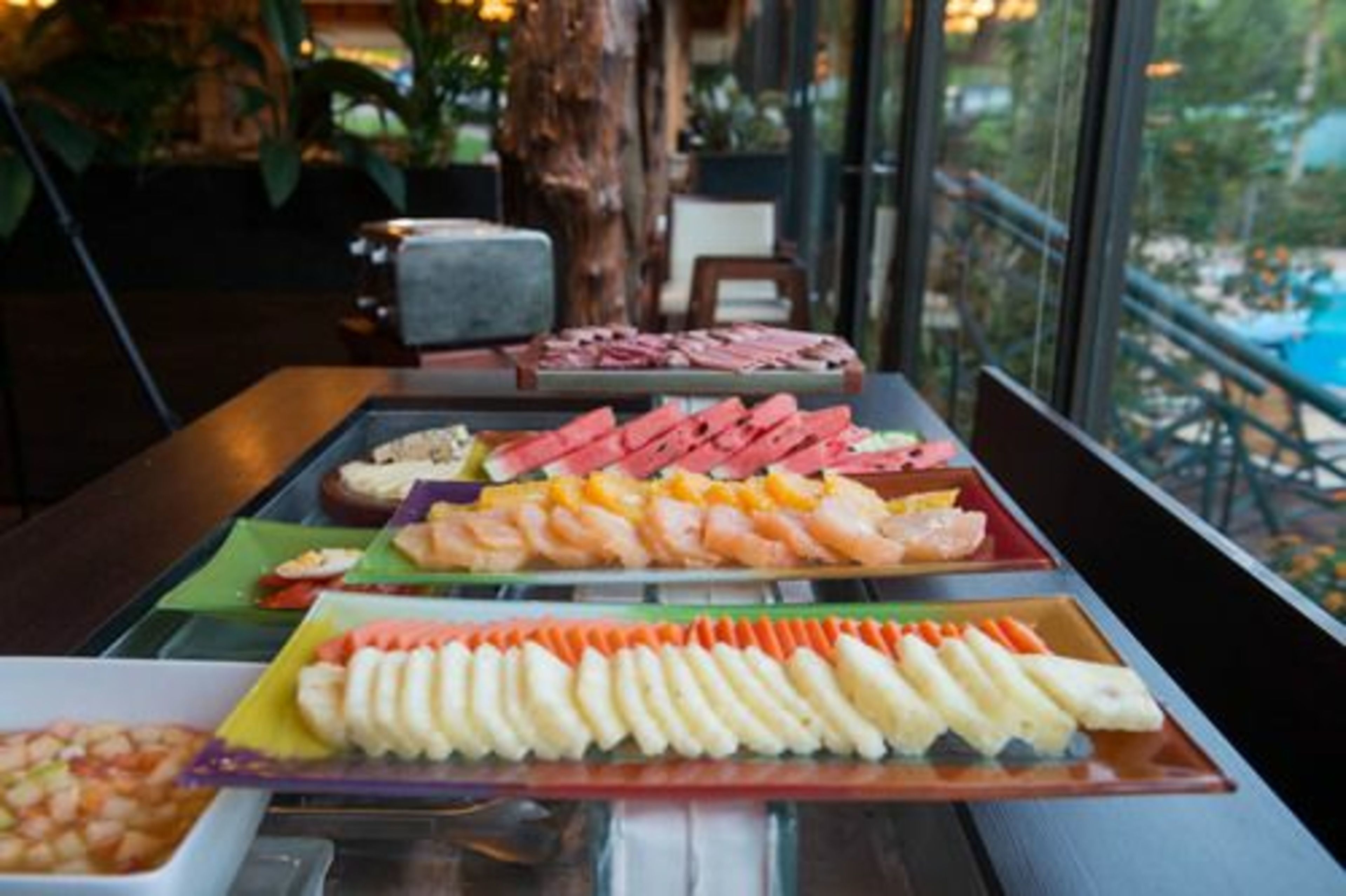 Ein Buffet mit verschiedenen Speisen, darunter Garnelen, Wassermelone und weitere Gerichte.