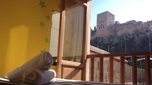 A room with a view of a historic castle. - White Nest (Granada)