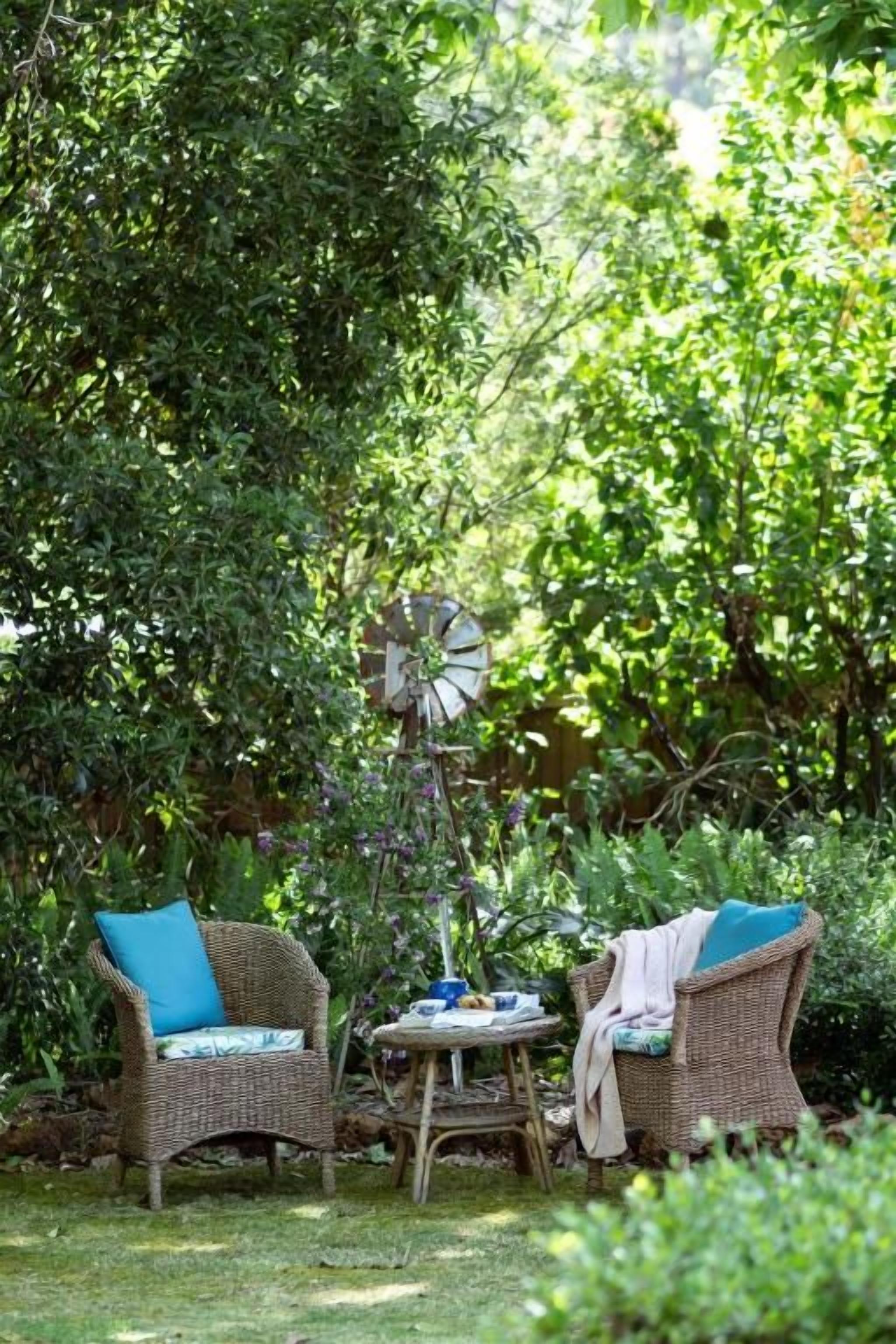 An outdoor seating area with wicker furniture and a windmill.