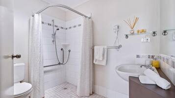 A bathroom with a shower, toilet, and sink.