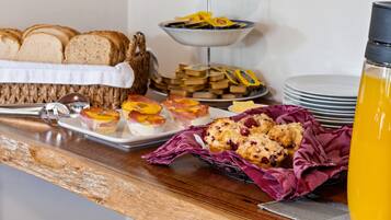 A breakfast buffet with various pastries, bread, and a water bottle.