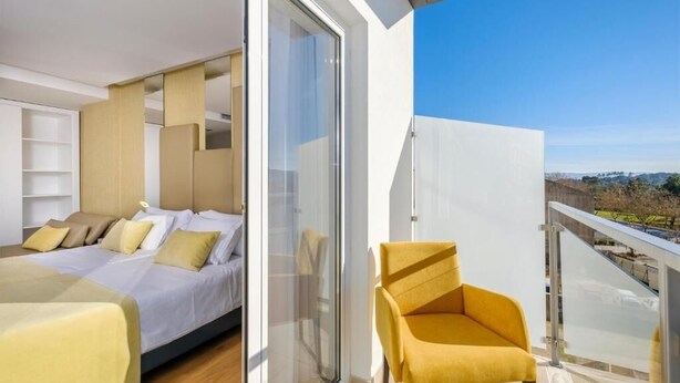 Une chambre moderne avec un lit, une chaise et un balcon offrant une vue agréable.