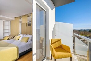 A modern bedroom with a bed, a chair, and a balcony with a view. - Hotel Rosa Mística by Umbral (Ourem)
