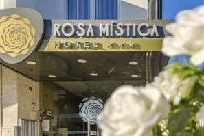 The exterior of Rosa Mística Hotel with a prominent rose design and a sign indicating a 5-star rating.