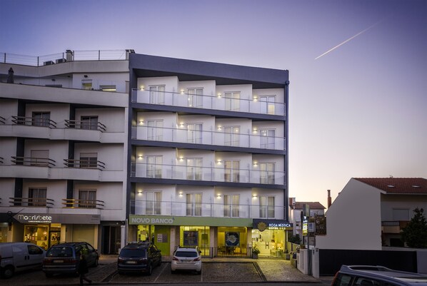 A multi-story hotel with balconies, a visible bank, and a restaurant.