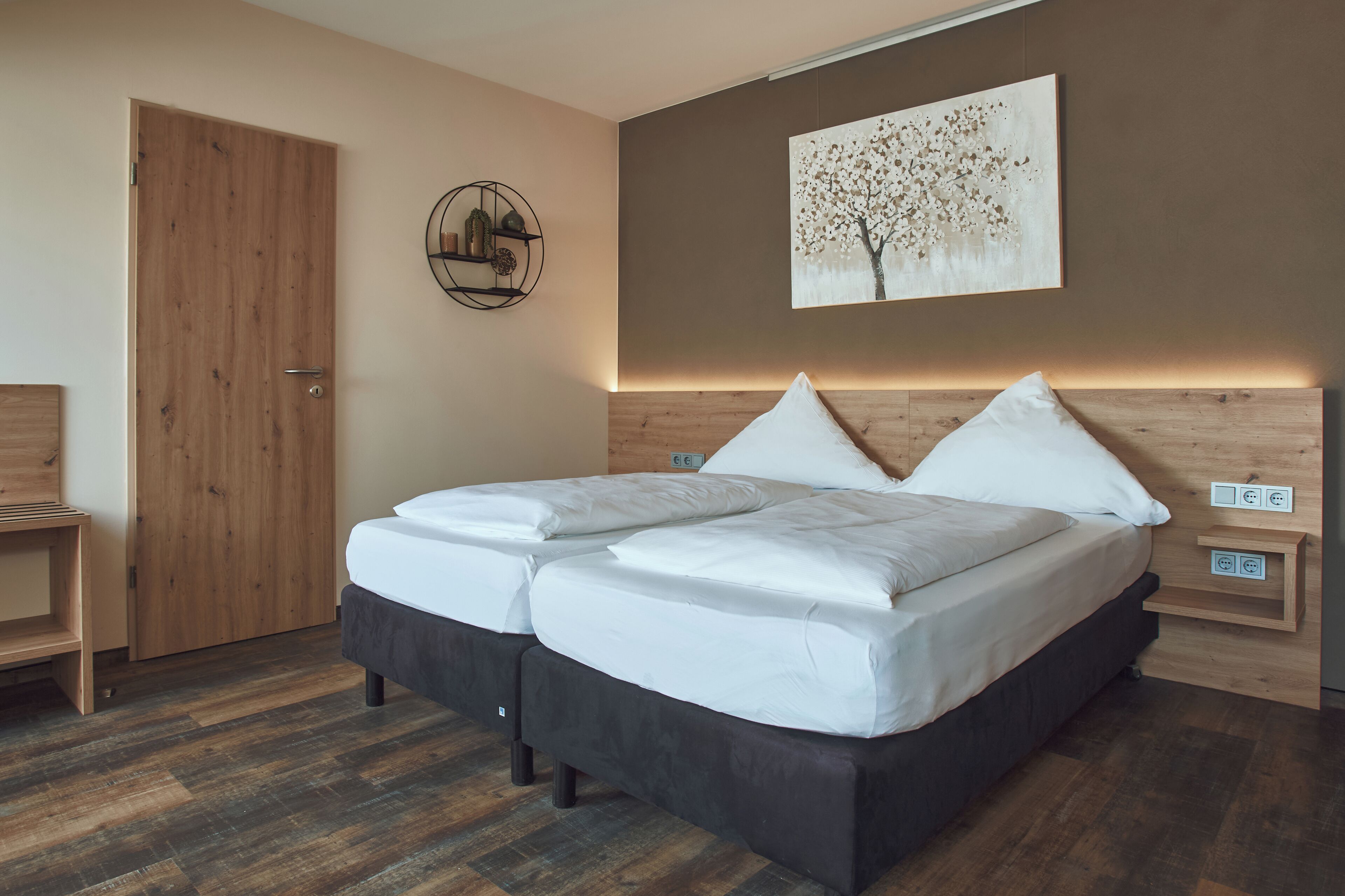 Un dormitorio con una cama de madera, un estante en la pared y una puerta.