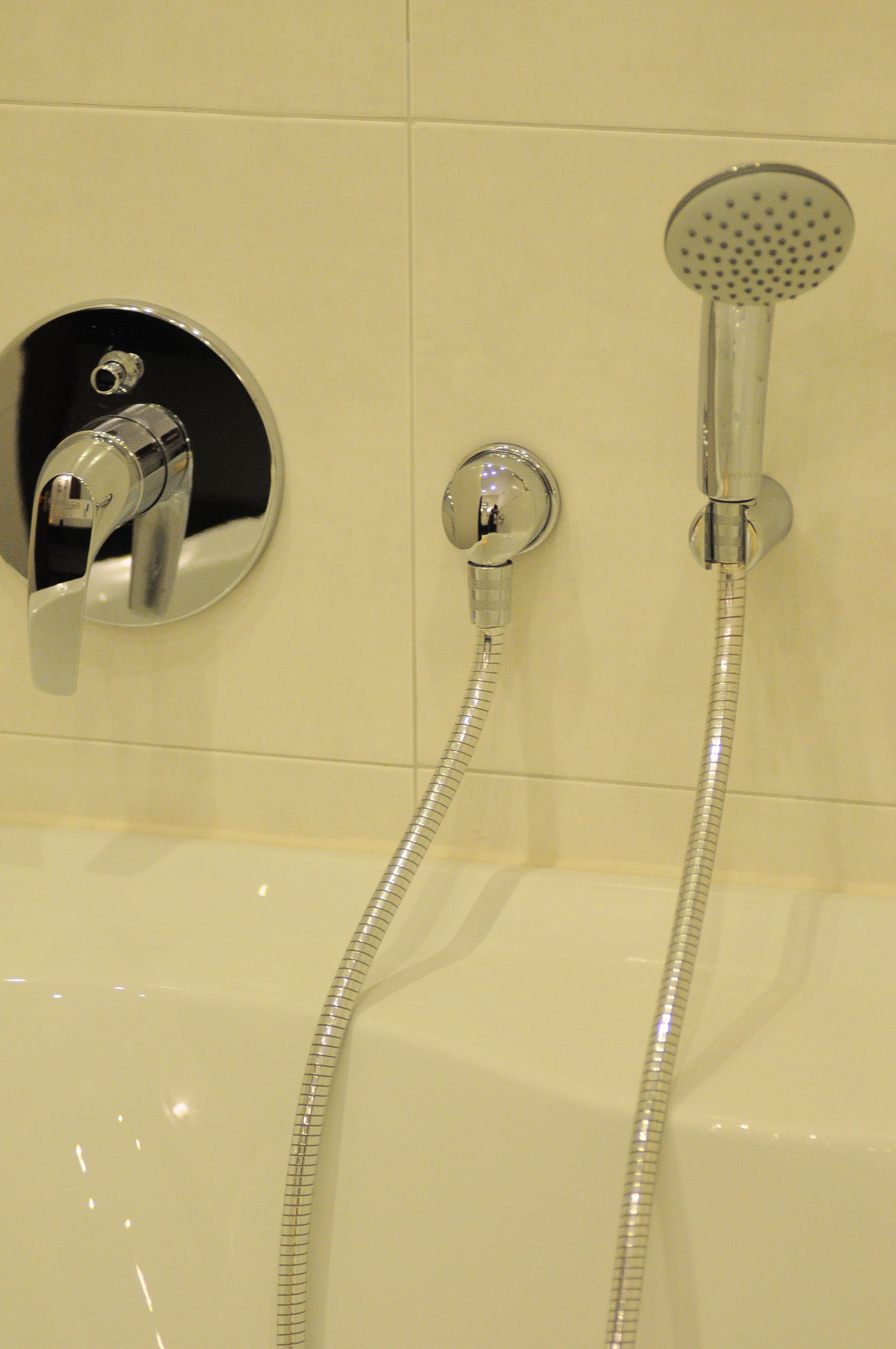 Un baño con bañera, ducha de mano y grifo empotrado.