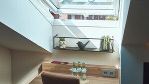 Een dakraam met uitzicht op een gebouw en zonnepanelen.