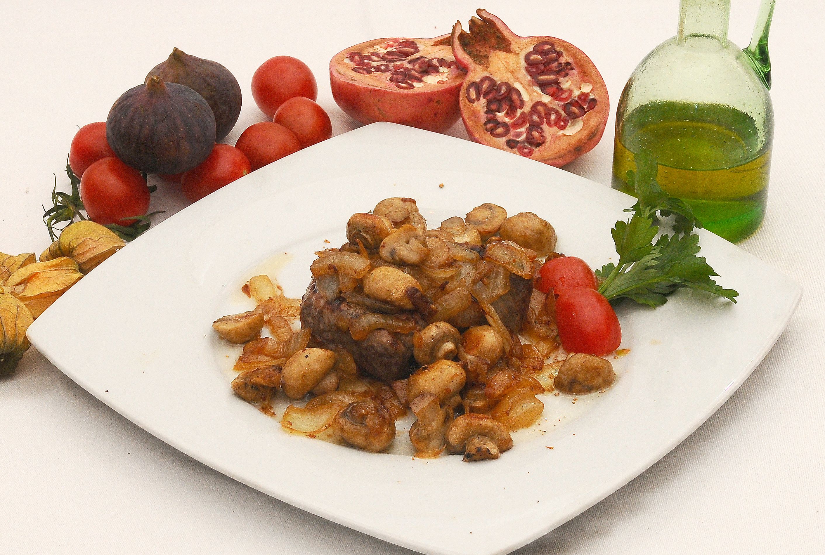 A plate of food with vegetables and a bottle of oil.