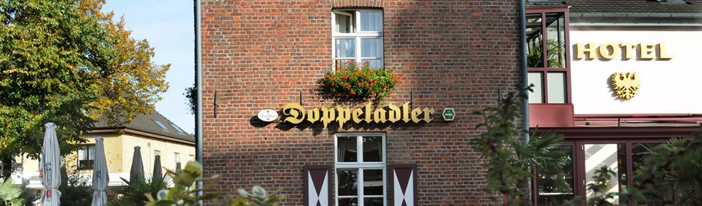 A brick building with a sign that reads "Doppeladler" and a "HOTEL" sign above it.