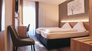 Een hotelkamer met een bed, een bureau, een stoel en een televisie.
