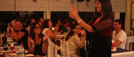 A woman clapping at a dinner event.