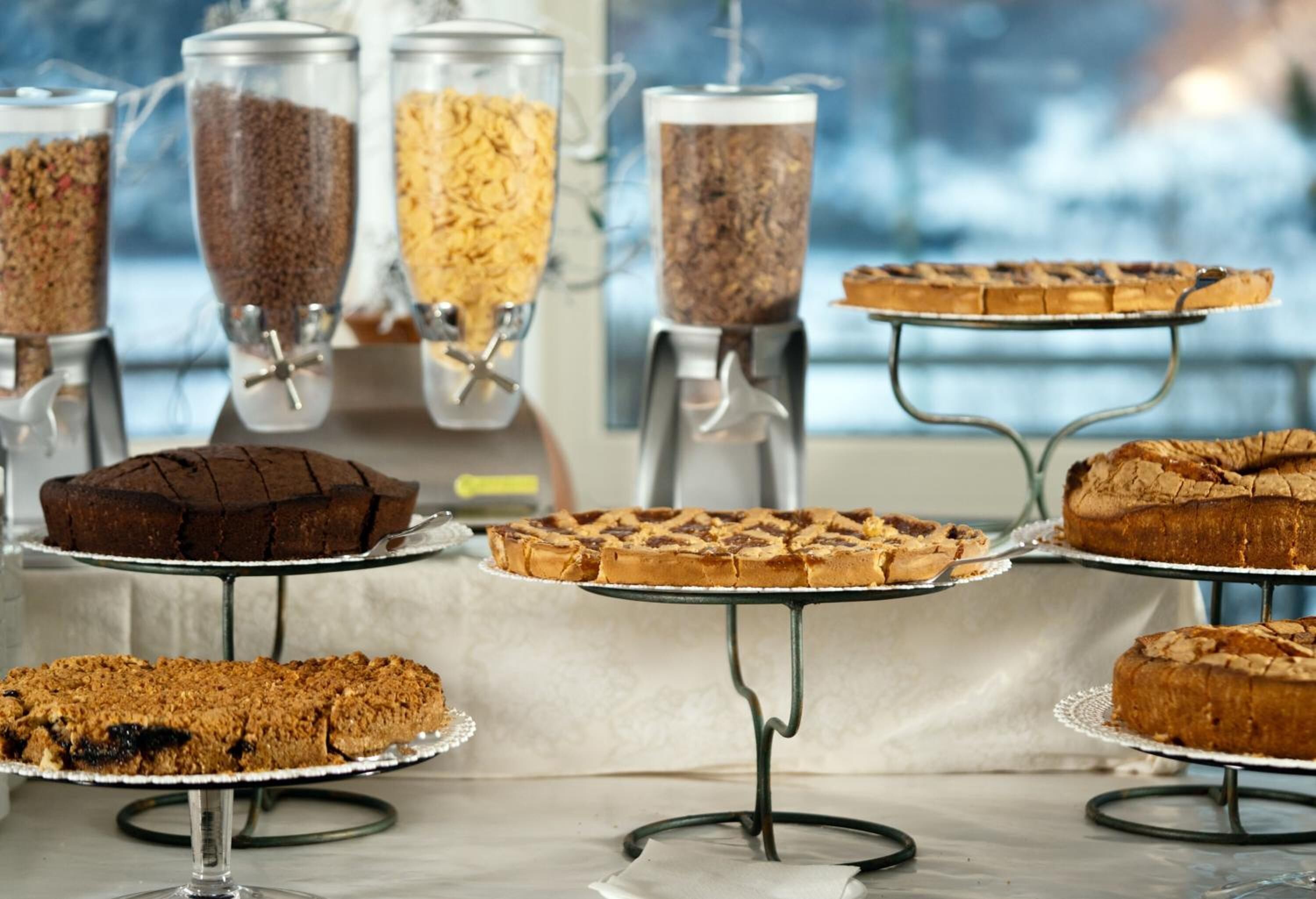 A buffet with various cakes and a coffee station.