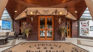 De ingang van het Cipriani Park Hotel, met een houten gevel, een dubbele deur en een welkomstmat met de naam van het hotel.
