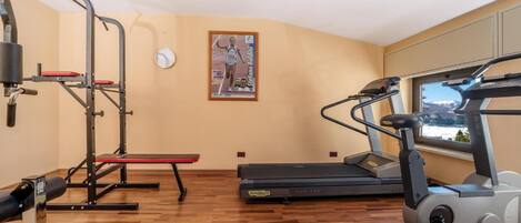 A gym with cardio equipment, a bench, and a treadmill.