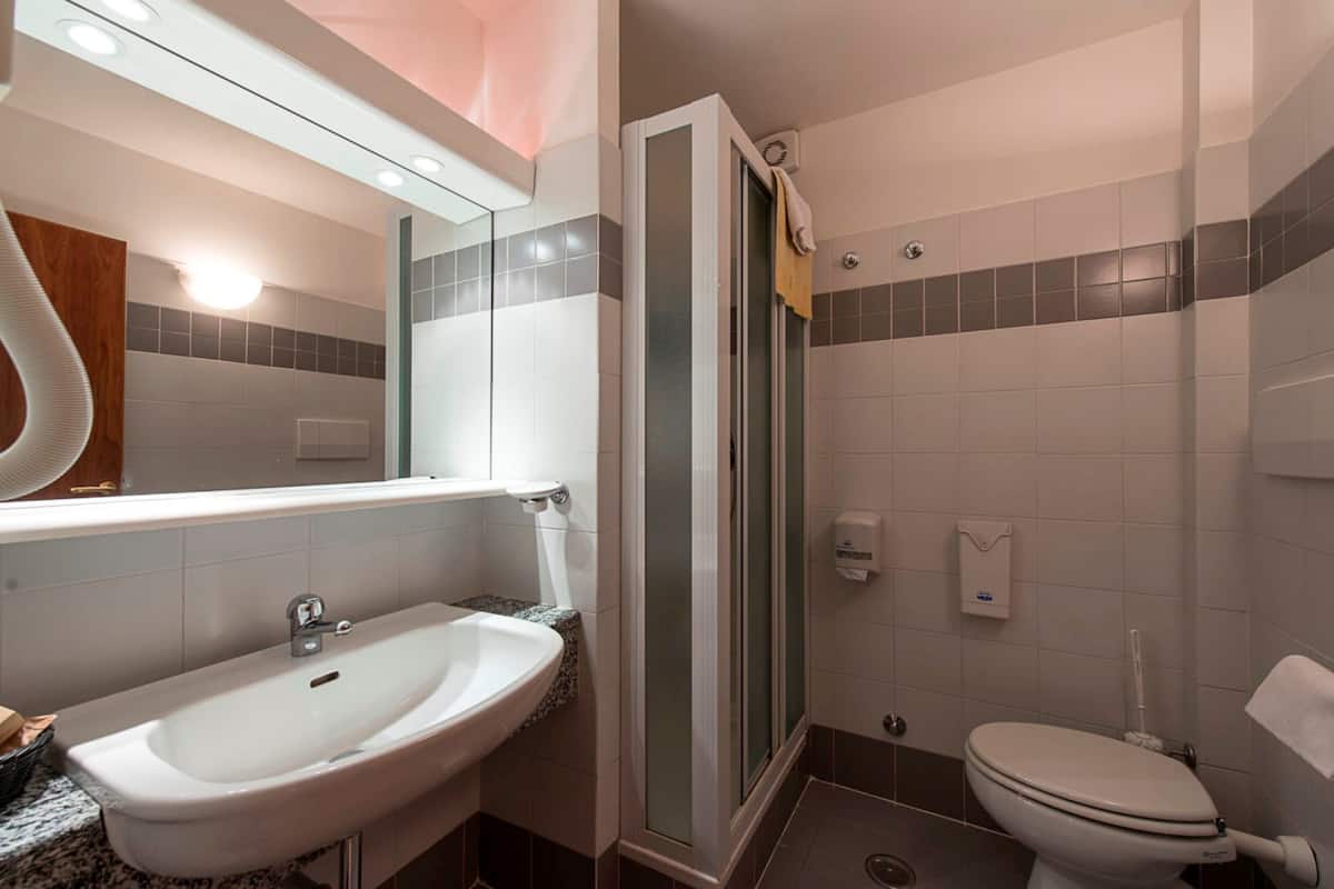 A bathroom with a sink, toilet, and shower.