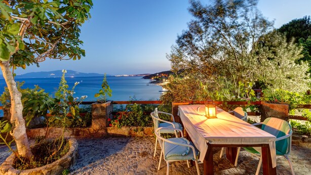 A table set outdoors with a view of the sea and mountains. - Assos Terrace Hotel (Ayvacik)
