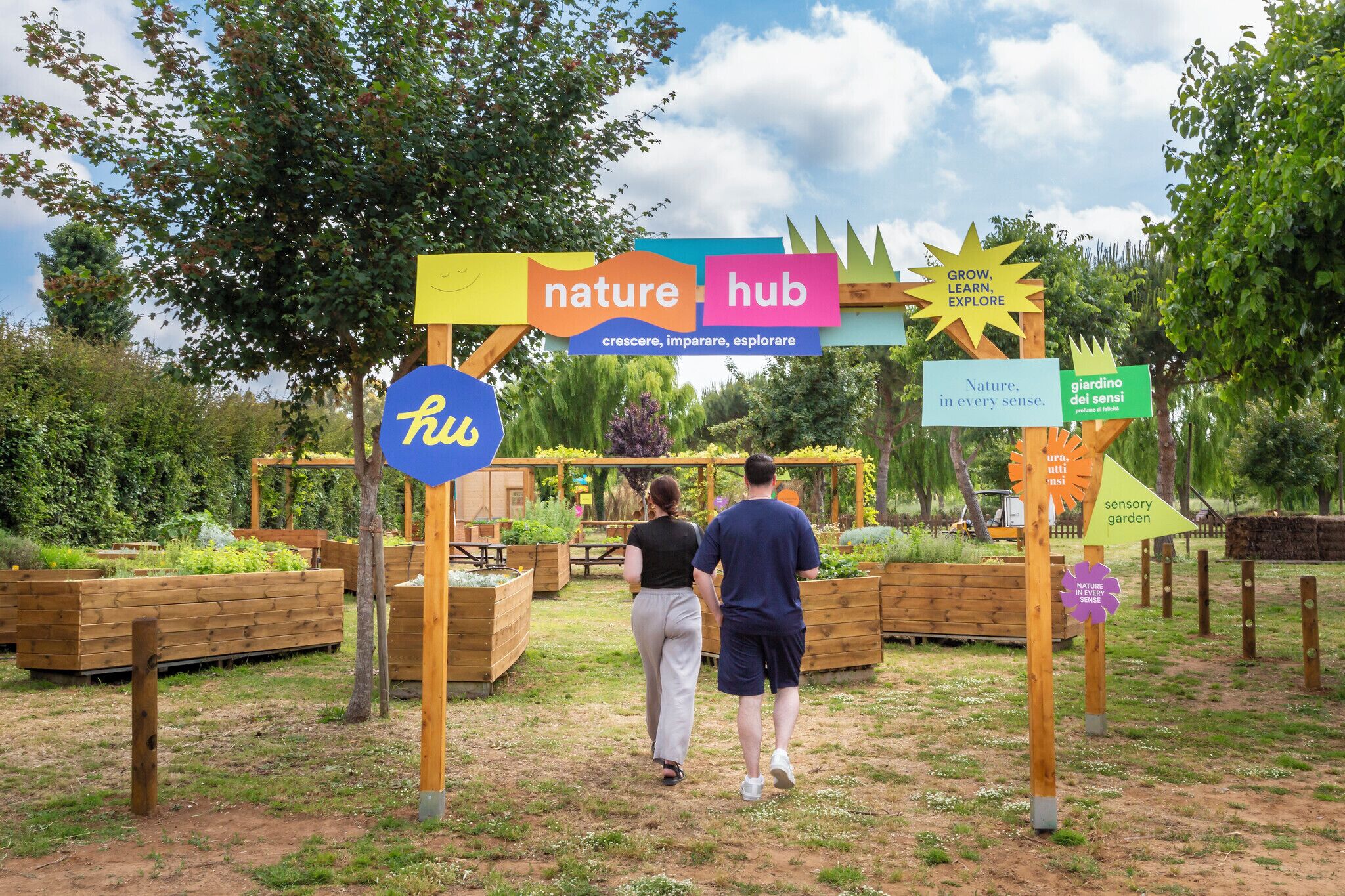 Un espace jardin aménagé avec des jardinières en bois et une pancarte indiquant « espace nature ».