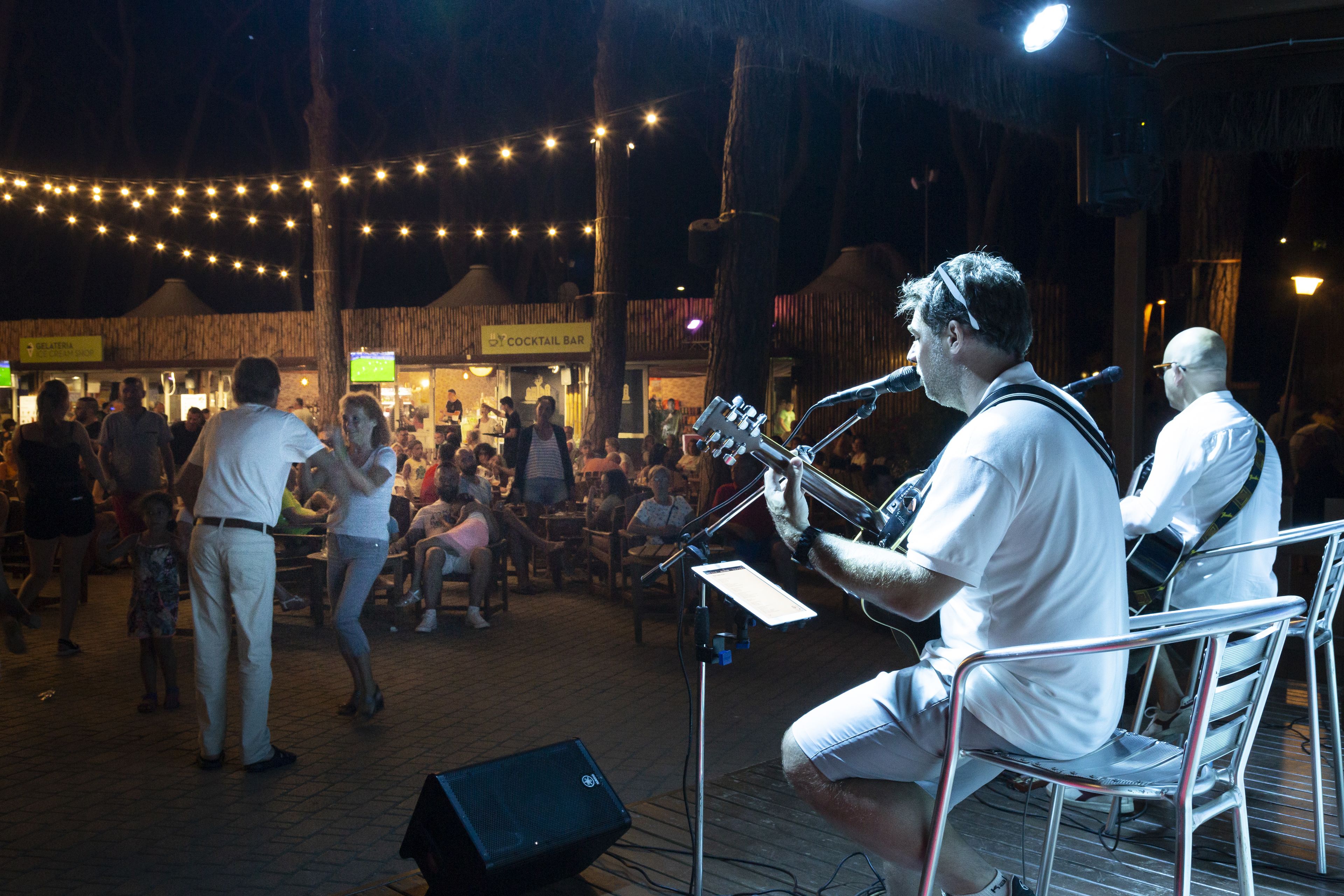 A musician performing on a stage with an audience.