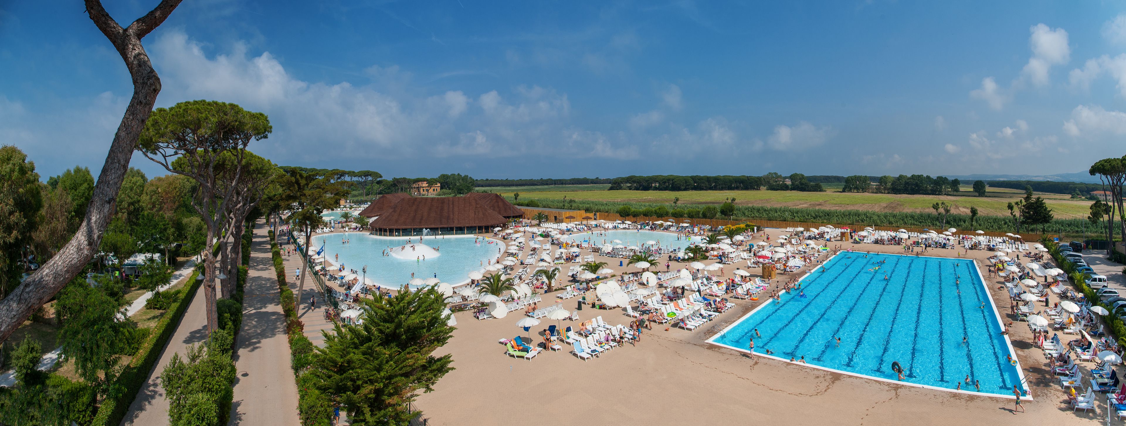 Un complexe hôtelier doté de plusieurs piscines, de chaises longues et d’un espace de plage.