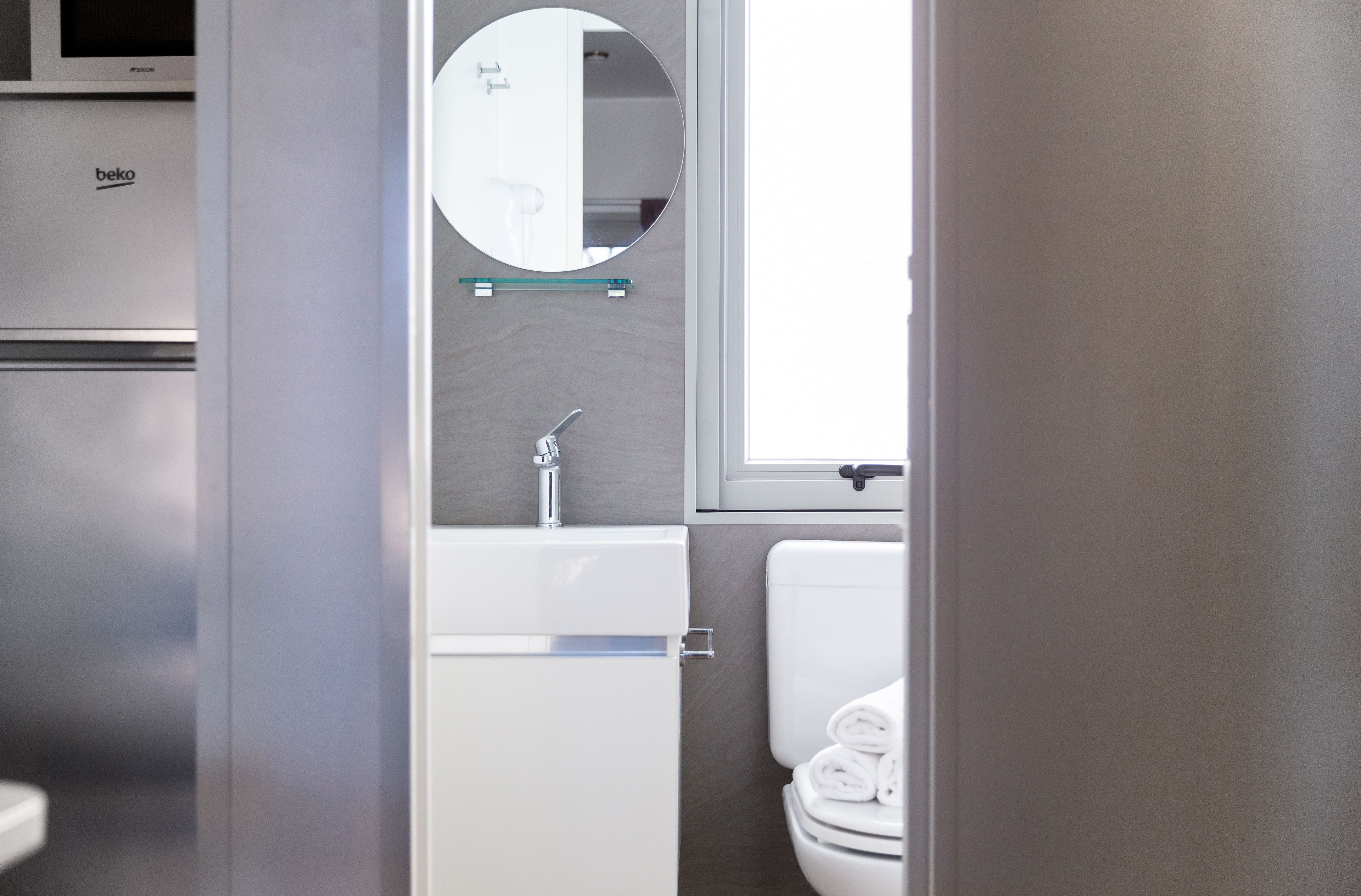 A modern bathroom with a toilet, sink, and mirror.