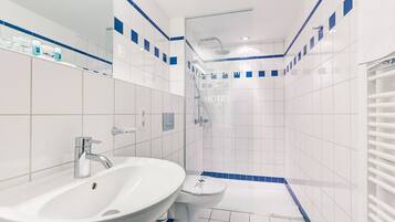 Un baño moderno con un lavamanos grande, inodoro y zona de ducha.