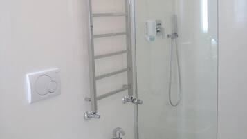 Une salle de bain moderne avec une douche à parois de verre, un lavabo blanc, un bidet et des toilettes.