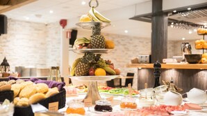 Een buffet met diverse soorten eten, zoals fruit, kazen en vlees.